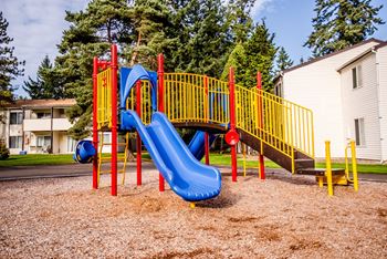 a playground with a blue slide and yellow playset